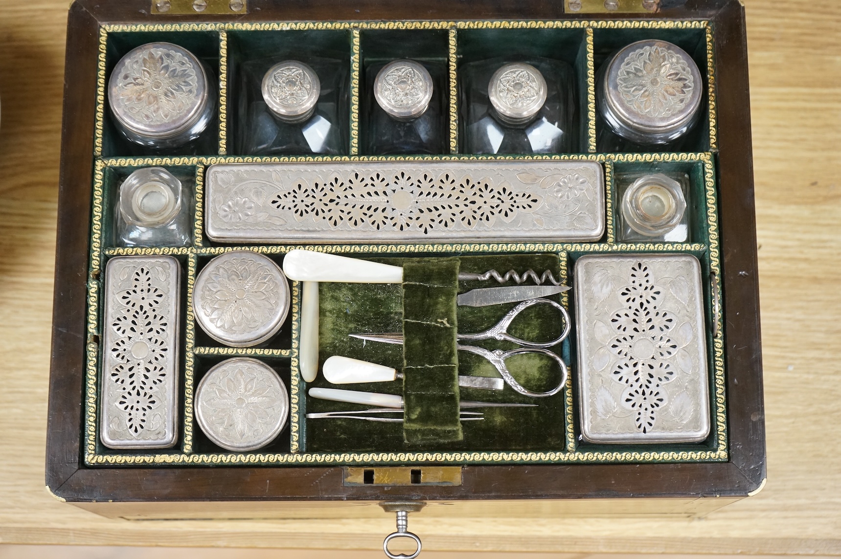 A mid 19th century mahogany brass bound and mounted toilet box, with tooled leather and velvet interior. Fitted inside with glass plated topped bottles and boxes. 31cm wide x 19cm high
